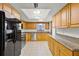 Kitchen featuring stainless steel appliances, wooden cabinetry, granite counters, and tile flooring at 1220 Rolling Ln, Casselberry, FL 32707