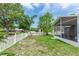 A view of the fenced yard with a pond and a screened-in patio at 13624 Springtide Ct, Orlando, FL 32826