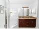Bathroom featuring shower, large tub, dual vanity with brown cabinets and big mirror at 13624 Springtide Ct, Orlando, FL 32826