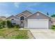 Charming single-story home with well-manicured lawn and attached two-car garage at 13624 Springtide Ct, Orlando, FL 32826