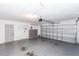 A garage with white walls, a light grey floor, and a white garage door at 13624 Springtide Ct, Orlando, FL 32826