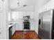 Well-lit kitchen with stainless steel appliances, white cabinets, and unique tile flooring at 13624 Springtide Ct, Orlando, FL 32826