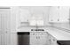 Clean kitchen with stainless steel dishwasher and sink with white cabinets and black backsplash at 13624 Springtide Ct, Orlando, FL 32826