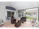 Cozy screened-in patio featuring stylish tile flooring and comfortable wicker furniture set at 13624 Springtide Ct, Orlando, FL 32826