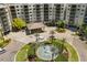 An aerial view of the water fountain, porte cochere and lush landscaping at 14501 Grove Resort Ave # 1441, Winter Garden, FL 34787