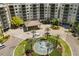 Stunning aerial view of the condo entrance with a beautiful water fountain and meticulously landscaped roundabout at 14501 Grove Resort Ave # 1441, Winter Garden, FL 34787