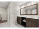 Bathroom featuring double vanity sinks, a large mirror, and a well-organized closet with ample storage at 14501 Grove Resort Ave # 1441, Winter Garden, FL 34787