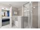 Modern bathroom featuring a tub and shower with glass doors, white tile, and a view into the bedroom at 14501 Grove Resort Ave # 1441, Winter Garden, FL 34787