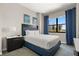 Comfortable bedroom features a queen bed, cool-toned accent wall, stylish curtains, and exterior views at 14501 Grove Resort Ave # 1441, Winter Garden, FL 34787