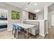 Bright dining area featuring a table with booth seating and a modern, open-concept kitchen with dark cabinets at 14501 Grove Resort Ave # 1441, Winter Garden, FL 34787