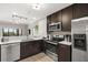 Modern kitchen with stainless steel appliances, dark cabinets, and ample counter space at 14501 Grove Resort Ave # 1441, Winter Garden, FL 34787