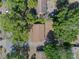 An aerial view of home with brown roof, surrounded by lush greenery and adjacent to paved streets at 1531 Jefferson Dr, Mount Dora, FL 32757