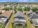 Lovely aerial view of a screened in pool in a neighborhood surrounded by lush green trees and beautiful blue skies at 166 Laurel Ridge Pass, Davenport, FL 33897