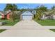 Charming blue home with a well-maintained lawn and a long driveway leading to an attached two-car garage at 212 Hound Run Pl, Casselberry, FL 32707