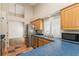 Well-lit kitchen with stainless steel appliances, wood cabinets, and blue countertops, providing a functional cooking space at 212 Hound Run Pl, Casselberry, FL 32707