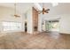 Open living room featuring high ceilings, a brick fireplace, tile flooring, and access to the backyard through sliding doors at 212 Hound Run Pl, Casselberry, FL 32707