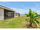 A lush backyard offers a serene escape and views of a tranquil lake from the screened in patio at 260 Lake Smart Cir, Winter Haven, FL 33881