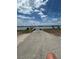 Concrete boat ramp leading into the serene lake with a dock to the left, under a partly cloudy sky at 260 Lake Smart Cir, Winter Haven, FL 33881