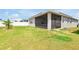 A spacious yard surrounds the screened-in patio, offering a view of the home's exterior and backyard at 260 Lake Smart Cir, Winter Haven, FL 33881