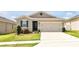 Charming single-story home featuring a two-car garage, landscaped yard, and inviting front entrance at 260 Lake Smart Cir, Winter Haven, FL 33881