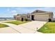 Beautiful home with a well-maintained lawn, a two-car garage, and a view of the water nearby at 260 Lake Smart Cir, Winter Haven, FL 33881