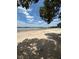 Picturesque lakeside beach featuring sandy shores, calm waters, a wooden dock, and trees in the distance at 260 Lake Smart Cir, Winter Haven, FL 33881