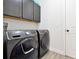 Laundry room with a gray washer and dryer, gray cabinets, and wood-look tile floors at 260 Lake Smart Cir, Winter Haven, FL 33881