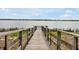 A wooden dock stretches over the serene lake, inviting peaceful moments and waterfront enjoyment at 260 Lake Smart Cir, Winter Haven, FL 33881