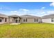 Expansive backyard with a covered patio, lush green grass, and views of the neighboring homes at 3823 Pronghorn Dr, St Cloud, FL 34772