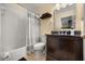 Well lit bathroom with dark wood cabinet, toilet, tub, and shower combo at 5000 Ashford Falls Ln, Oviedo, FL 32765