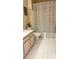 Bathroom with a patterned shower curtain, clean tile flooring, and light wood vanity at 5471 Vineland Rd # 7109, Orlando, FL 32811