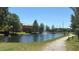 Walkway alongside the community pond, complete with a fountain and park benches at 5471 Vineland Rd # 7109, Orlando, FL 32811