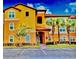 Inviting condo with well-maintained landscaping and vibrant yellow facade at 5471 Vineland Rd # 7109, Orlando, FL 32811