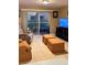 Inviting living room with neutral tones, tile flooring, and a sliding glass door to an outdoor seating area at 5471 Vineland Rd # 7109, Orlando, FL 32811