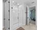 Modern bathroom featuring a glass-enclosed shower, white tile, and access to the bedroom, designed for comfort at 5981 Sierra Crown St, Mount Dora, FL 32757