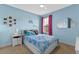 Bright blue bedroom with a bed, cloud decor, and a window, creating a playful and serene atmosphere at 5981 Sierra Crown St, Mount Dora, FL 32757
