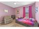 Pink bedroom with a bed, comfortable chair, and artwork, creating a cozy and inviting space at 5981 Sierra Crown St, Mount Dora, FL 32757