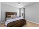 Comfortable bedroom featuring a large wooden bed frame, soft carpet, and a window letting in natural light at 5981 Sierra Crown St, Mount Dora, FL 32757