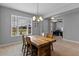 Inviting dining room with a rustic wooden table, chandelier, and large window, offering a cozy atmosphere at 5981 Sierra Crown St, Mount Dora, FL 32757