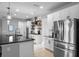 Modern kitchen featuring stainless steel appliances, a black granite countertop island, and white cabinets at 5981 Sierra Crown St, Mount Dora, FL 32757