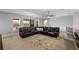 Bright living room with a large leather sectional, decorative pillows, and a ceiling fan above at 5981 Sierra Crown St, Mount Dora, FL 32757