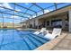 Screened in pool with a sun shelf, seating area, and outdoor kitchen at 5981 Sierra Crown St, Mount Dora, FL 32757