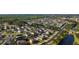Scenic aerial view of a residential neighborhood featuring tree-lined streets, well-maintained homes, and a tranquil pond at 690 Cascading Creek Ln, Winter Garden, FL 34787
