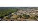 Expansive aerial view of a residential area bordering a lush forest, with community amenities including a playground at 690 Cascading Creek Ln, Winter Garden, FL 34787