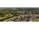 An aerial view highlights a charming neighborhood near a tranquil pond and lush green spaces at 690 Cascading Creek Ln, Winter Garden, FL 34787
