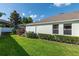 Well-maintained backyard featuring lush green grass, trimmed shrubs, and the home's exterior at 690 Cascading Creek Ln, Winter Garden, FL 34787