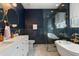 Stunning bathroom with navy tiled walls, dual sinks, and a soaking tub at 690 Cascading Creek Ln, Winter Garden, FL 34787