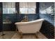 Close-up of luxurious soaking tub and shower with striking blue tile at 690 Cascading Creek Ln, Winter Garden, FL 34787