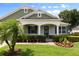 Charming single-story home featuring a well-manicured lawn, lush landscaping, and a welcoming front porch at 690 Cascading Creek Ln, Winter Garden, FL 34787