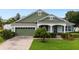 Charming single-story home featuring a well-manicured lawn, lush landscaping, and a welcoming front porch at 690 Cascading Creek Ln, Winter Garden, FL 34787